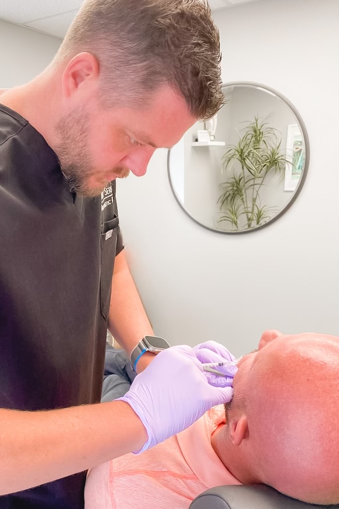 Expert cosmetologist providing injection for male customer cheeks | Botox in St. Cloud, MN | Simply Serene Wellness and Aesthetics